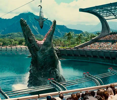 Mososaurio saltando para devorar a un tiburón blanco, mientras le observan muchos espectadores