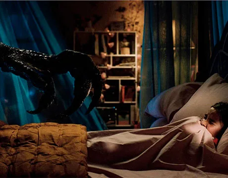 Maisie escondiéndose en su cama mientras se acerca un Indoraptor