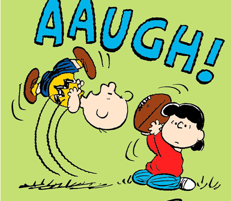 Lucy quitándole la pelota a Charlie Brown en la tira de cómics de Peanuts