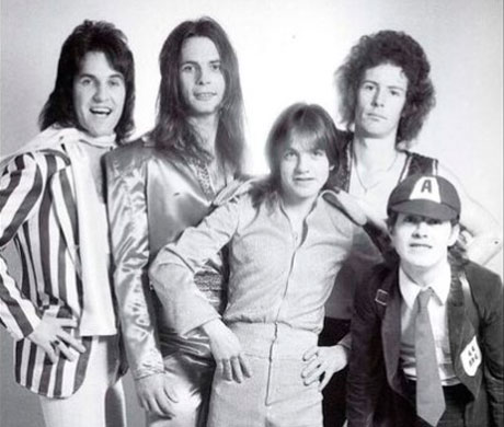 Fotografía de la banda de ACDC con Angus Young vestido con uniforme de colegio.