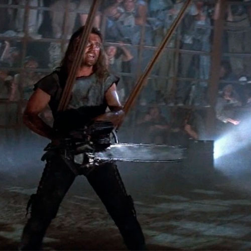 Fotografía de max con una motosierra en la tercera película de mad max.