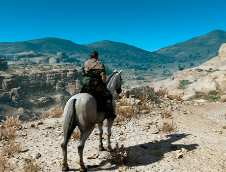 Imagen de Venom Snake montado a caballo en el desierto en el juego Metal Gear V: The Phantom Pain.